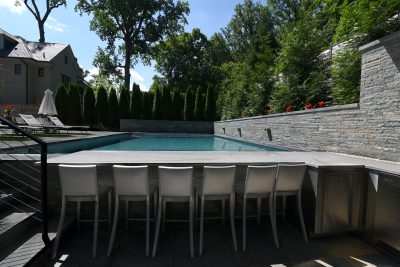 Sunken outdoor kitchen, pool. Hand-chiseled flagstone wall.