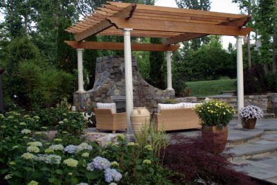 Stone patio with built-in fireplace and custom pergola